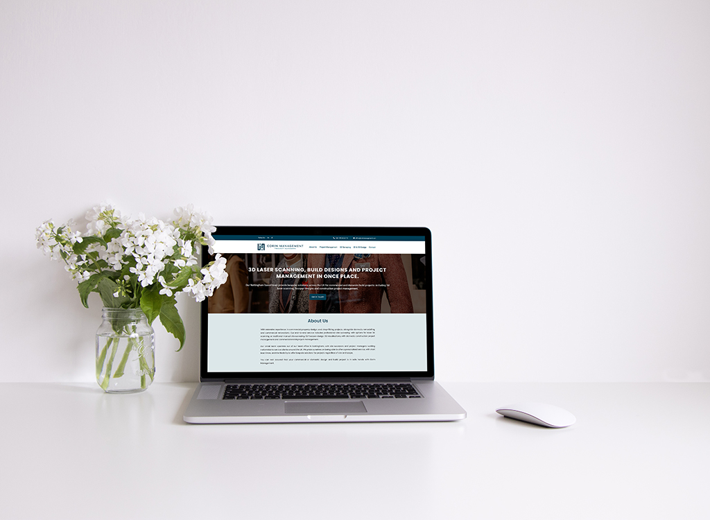 A laptop displaying a website focused on 3D laser scanning and project management, accompanied by a vase of white flowers on a clean desk.
