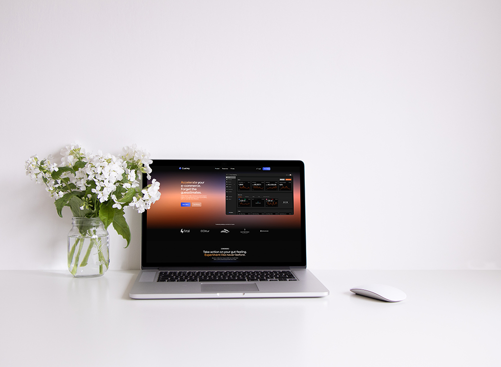 A modern laptop displaying an e-commerce platform on a clean workspace, accompanied by a vase of white flowers and a wireless mouse, emphasizing a professional and inviting atmosphere for online business.